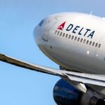 the front part of a Delta airplane being photographed while the aircraft is in flight