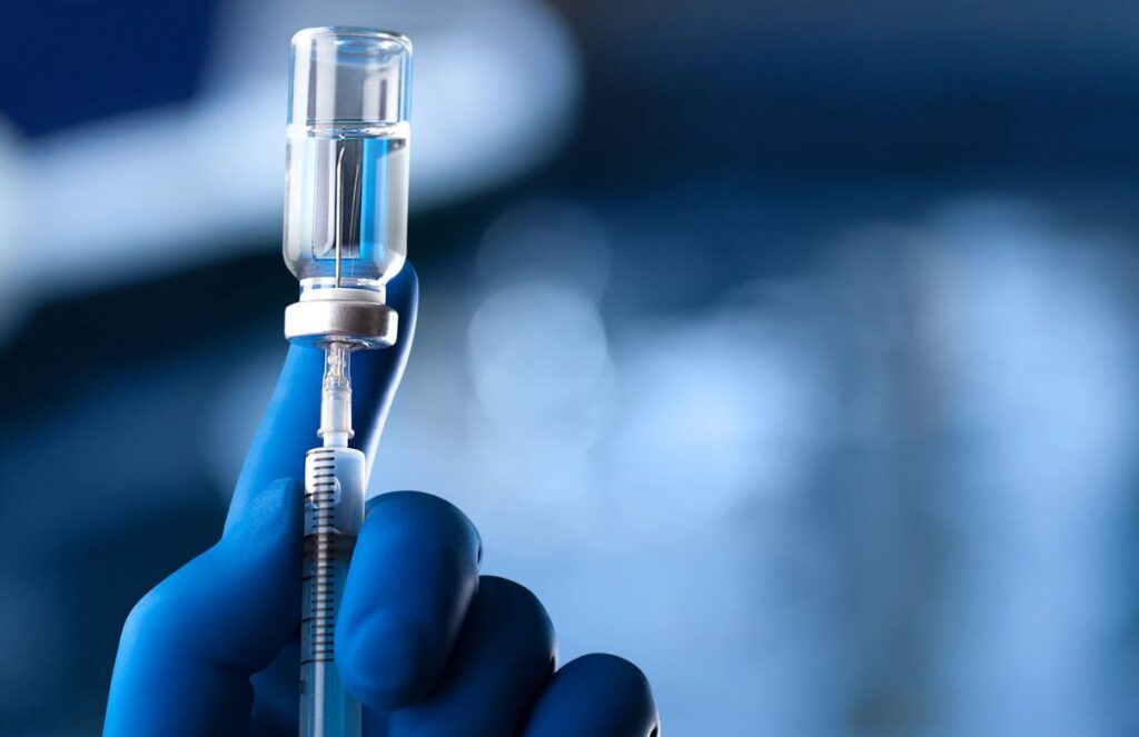 A medical worker drawing a vaccine into a syringe to administer it