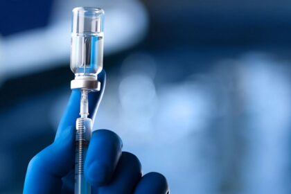 A medical worker drawing a vaccine into a syringe to administer it