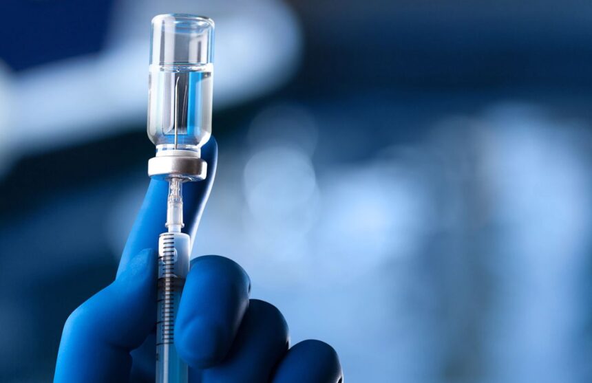 A medical worker drawing a vaccine into a syringe to administer it