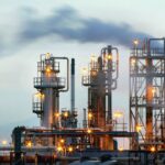 An oil plant operating and releasing smoke from its boilers