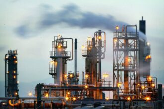 An oil plant operating and releasing smoke from its boilers