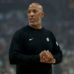 The former Portland coach applauding while walking across a basketball court