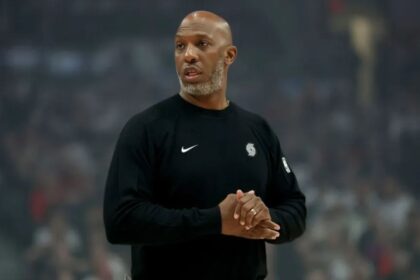 The former Portland coach applauding while walking across a basketball court