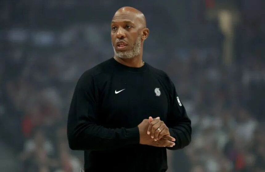 The former Portland coach applauding while walking across a basketball court