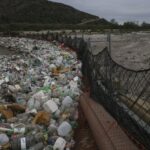 A river with a net stretching from side to side that collects all the trash passing through it