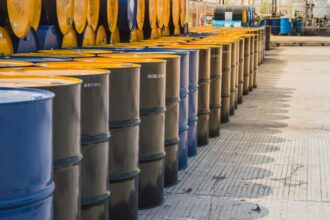 Many barrels piled up with oil in a warehouse