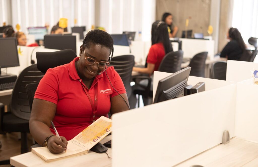 The United States aims to eliminate overseas call centers and shake up the job market A woman working at a call center in her office while writing in a notebook
