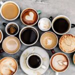 Several cups of coffee of different sizes, each with different designs on them