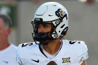 The young deceased player wearing his uniform and helmet in the middle of a game