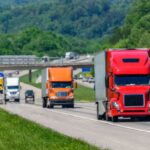 Several heavy trucks driving along a highway