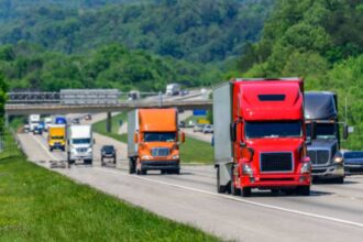 Several heavy trucks driving along a highway