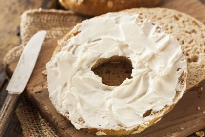 A piece of bread cut in half spread with a generous amount of cream cheese