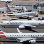Several American Airlines planes parked while receiving their passengers