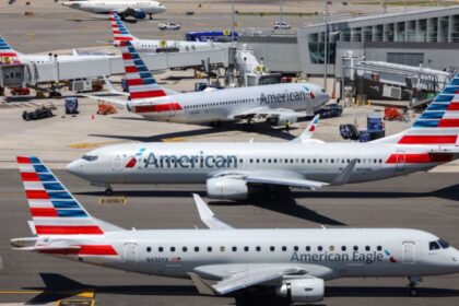 Several American Airlines planes parked while receiving their passengers