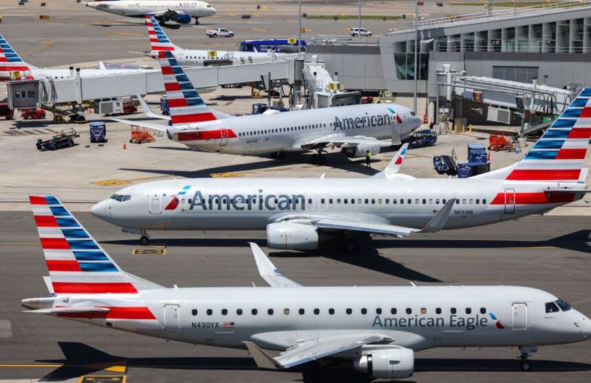 Several American Airlines planes parked while receiving their passengers
