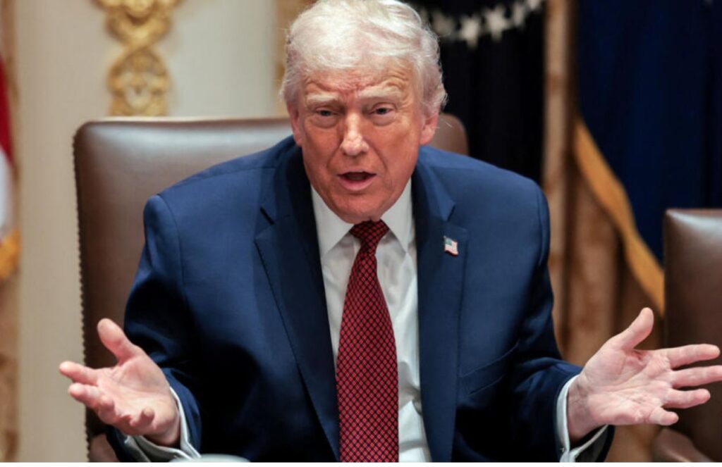 Donald Trump in his presidential office talking to someone with his arms open