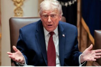 Donald Trump in his presidential office talking to someone with his arms open