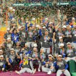 The Venezuelan team celebrating on a stage with lots of confetti and their championship title