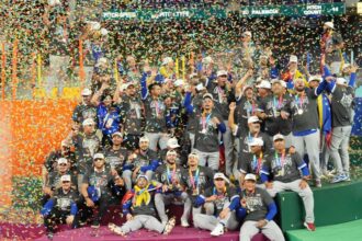 The Venezuelan team celebrating on a stage with lots of confetti and their championship title