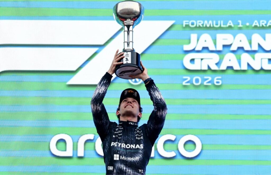 the young driver lifting a trophy after winning the F1 race in Japan