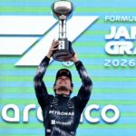 the young driver lifting a trophy after winning the F1 race in Japan