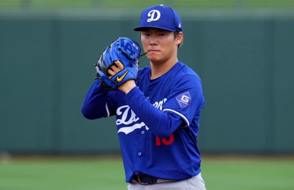 The incredible Japanese pitcher on the mound, about to throw the ball in the new blue Los Angeles Dodgers uniform.