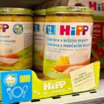 Two jars of baby food being displayed in a supermarket.