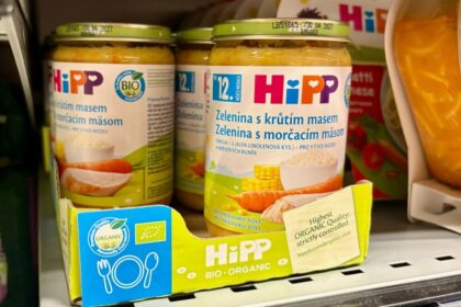 Two jars of baby food being displayed in a supermarket.