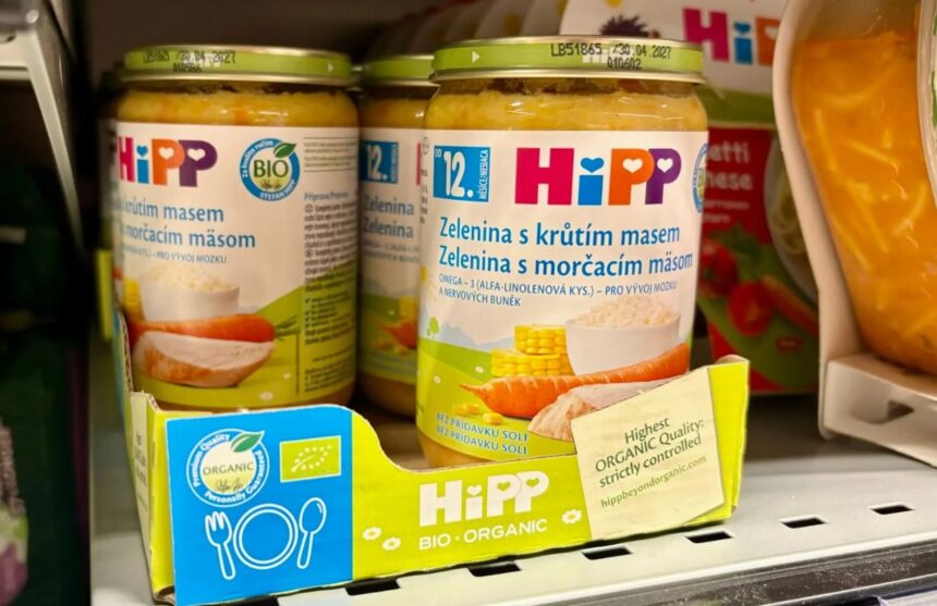 Two jars of baby food being displayed in a supermarket.