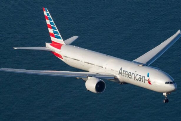 A white American Airlines airplane flying over the sea.