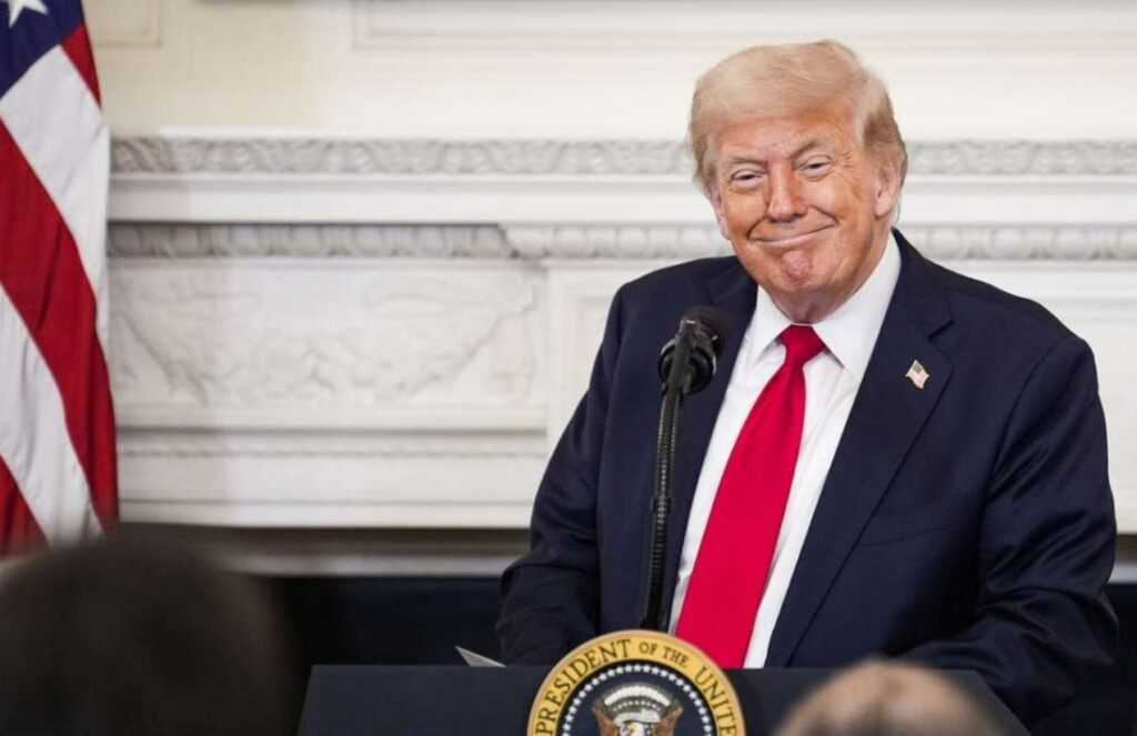 Donald Trump wearing an elegant suit speaking behind a podium.