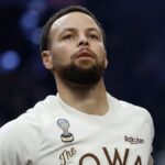 Stephen Curry on the court looking toward the stands while warming up for the game.