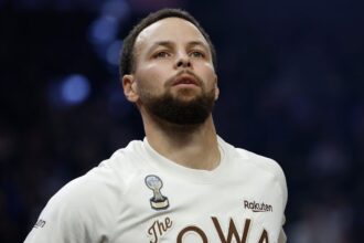 Stephen Curry on the court looking toward the stands while warming up for the game.