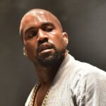 Kanye West in the middle of a concert, covered in sweat while performing his show
