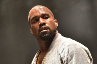 Kanye West in the middle of a concert, covered in sweat while performing his show
