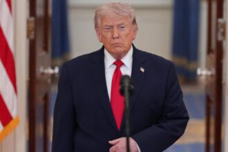 Donald Trump wearing an elegant suit while giving a press conference in front of cameras