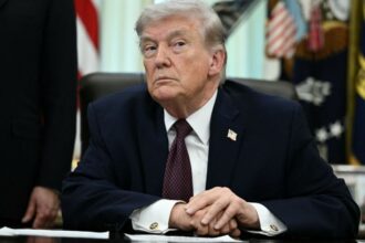 Trump with a very angry expression while looking at someone in the audience during a speech