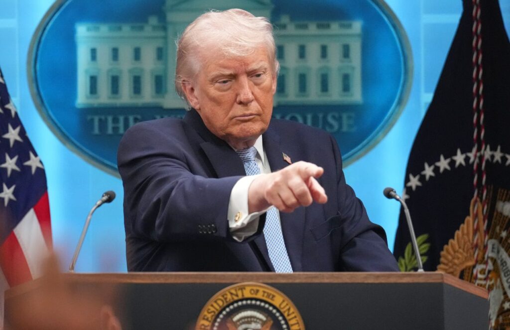 Donald Trump pointing his finger at a person during a conference