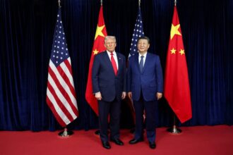 Donald Trump and Xi Jinping posing for a photo in front of their respective national flags.