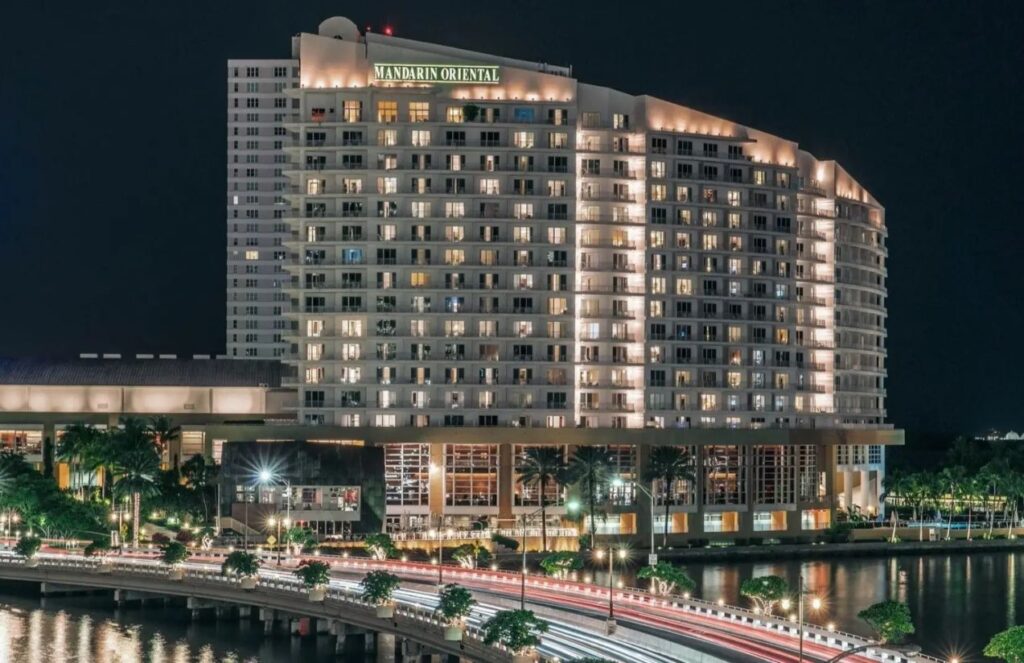 A panoramic nighttime photo of the hotel with all its lights on