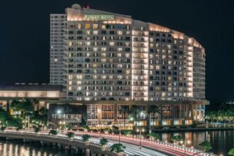 A panoramic nighttime photo of the hotel with all its lights on