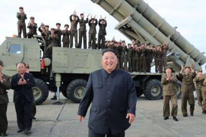 A panoramic image of the leader of North Korea with several soldiers behind him, riding in a bomber vehicle.