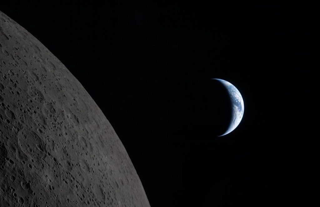 A historic photo of the Moon with a completely black background and planet Earth visible behind it.