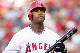 Anderson holding his bat while walking toward the batter’s box.