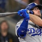 Max Muncy watching the ball leave the stadium after a powerful, game-winning hit.