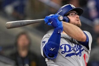 Max Muncy watching the ball leave the stadium after a powerful, game-winning hit.
