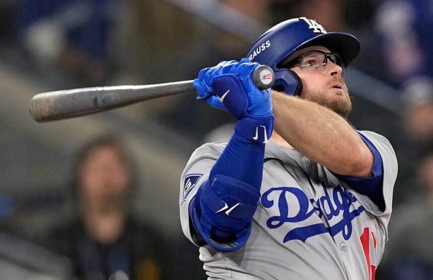 Max Muncy watching the ball leave the stadium after a powerful, game-winning hit.