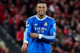 The outstanding French striker wearing the blue Real Madrid uniform with a slightly painful expression on his face.