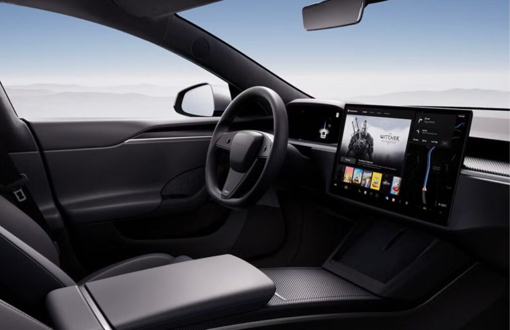 A Tesla car seen from the inside, showing its steering wheel and screen